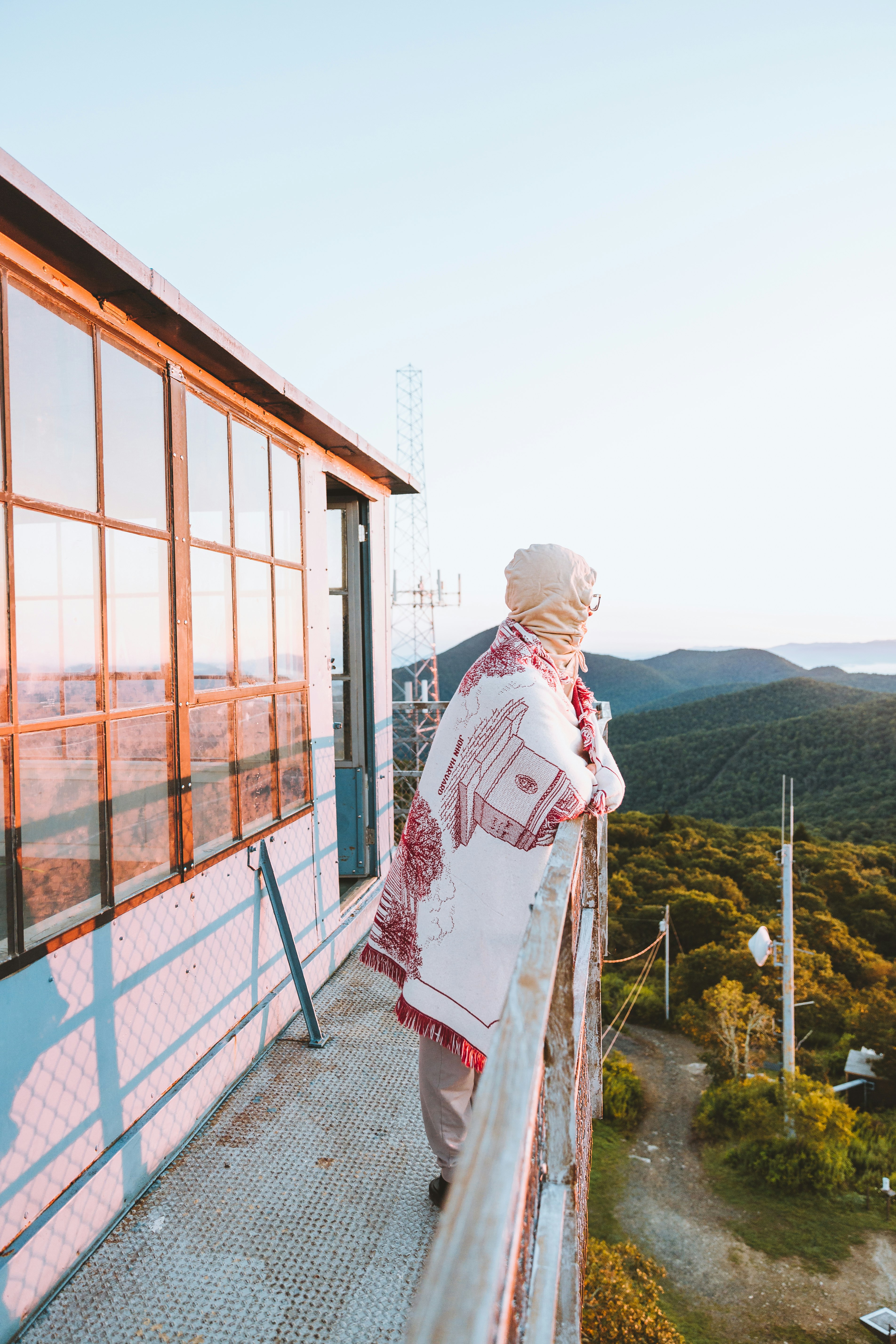 woman in white hijab standing near brown wooden fence during daytime